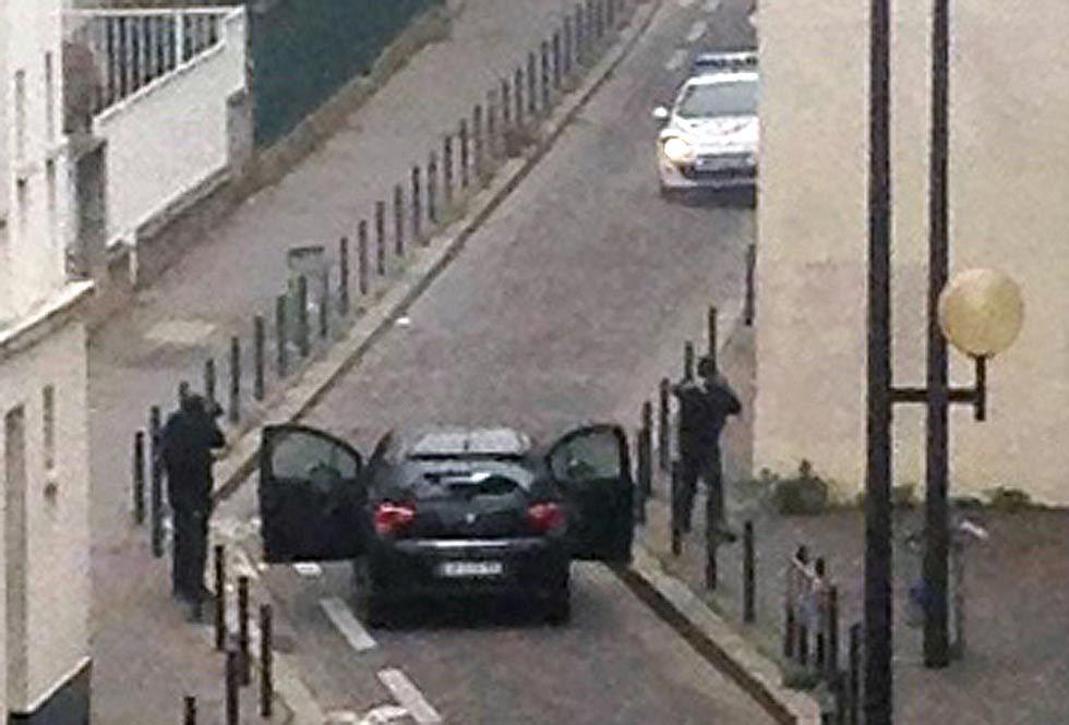 Armed gunmen are seen near the offices of the French satirical newspaper Charlie Hebdo in Paris on January 7, 2015, during an attack on the offices of the newspaper which left eleven dead, including two police officers, according to sources close to the investigation.