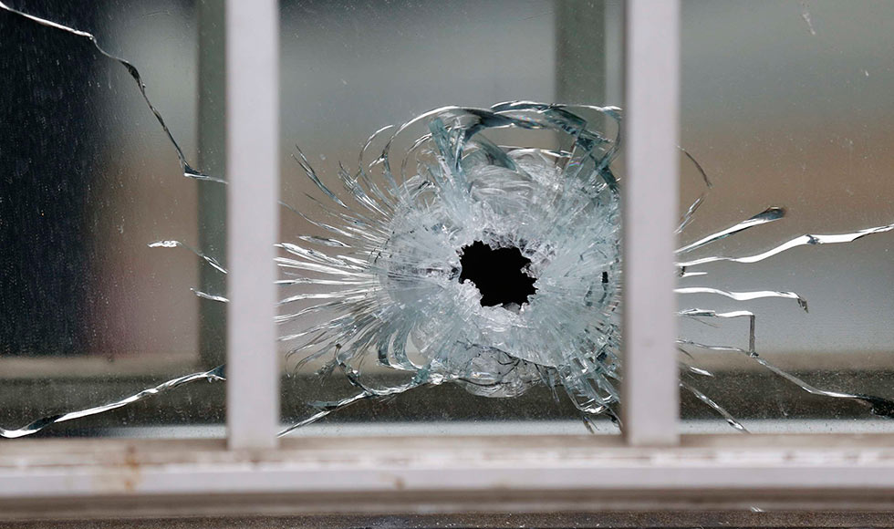 A bullet's impact is seen on a window at the scene after a shooting at the Paris offices of Charlie Hebdo, a satirical newspaper, January 7, 2015.