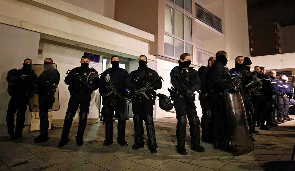 Police officers secure access to a residential building during investigations in the eastern French city of Reims January 8, 2015, after the shooting against the Paris offices of Charlie Hebdo, a satirical newspaper. An 18-year old man sought by police over Wednesday's shooting attack at the magazine handed himself voluntarily to police in northeastern France, an official at the Paris prosecutor's office said.