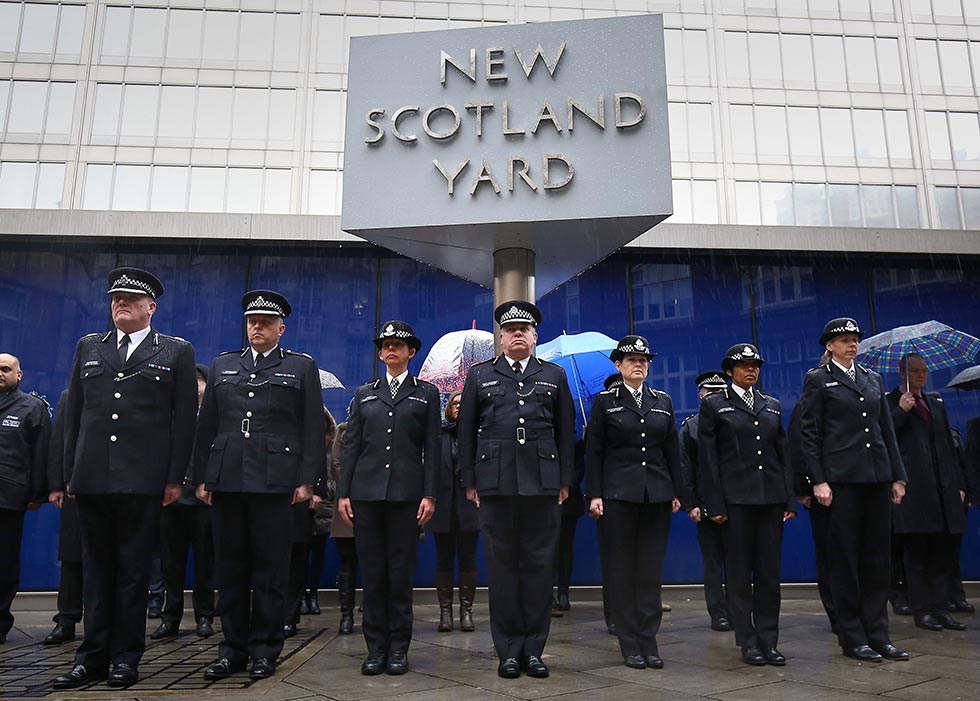 Metropolitan Police officers and staff during a two minute silence outside New Scotland Yard in London, in solidarity with those affected by the Charlie Hebdo massacre in France.