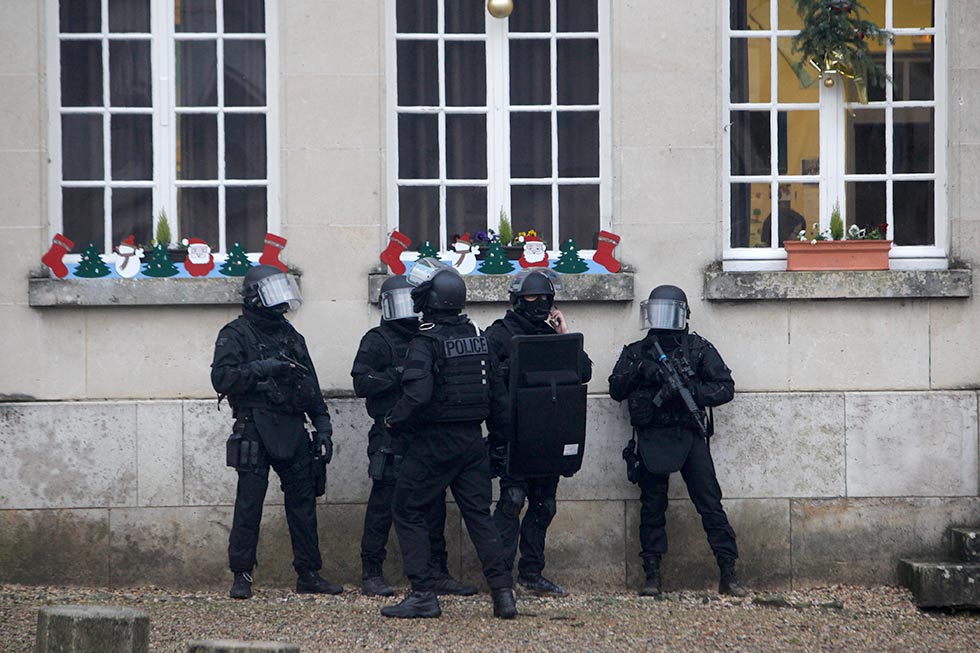 French riot officers patrol in Longpont, north of Paris, France, Thursday, Jan. 8, 2015. Scattered gunfire and explosions shook France on Thursday as its frightened yet defiant citizens held a day of mourning for 12 people slain at a Paris newspaper. French police hunted for the two heavily armed brothers suspected in the massacre to make sure they don't strike again.