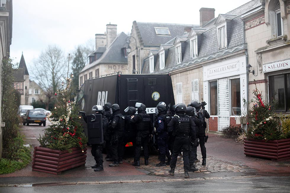 French riot officers patrol in Longpont, north of Paris, France, Thursday, Jan. 8, 2015. Scattered gunfire and explosions shook France on Thursday as its frightened yet defiant citizens held a day of mourning for 12 people slain at a Paris newspaper. French police hunted for the two heavily armed brothers suspected in the massacre to make sure they don't strike again.