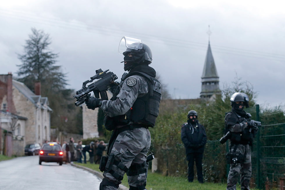 A member of the French GIPN intervention police forces secure a neighbourhood in Corcy, northeast of Paris