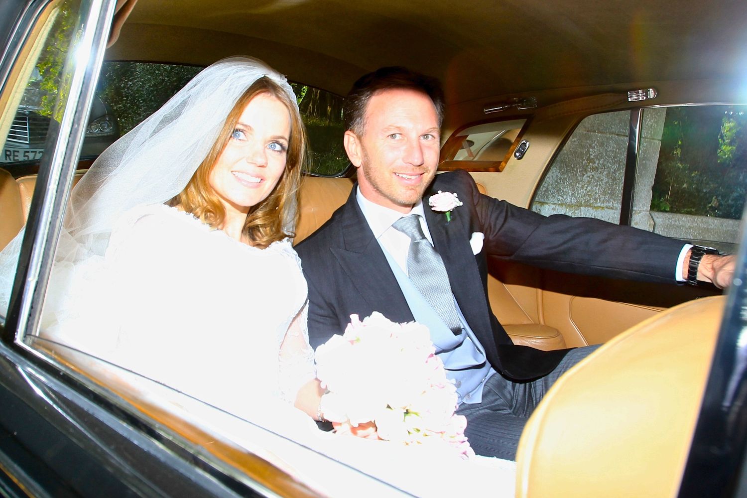 The newlyweds smile from their car