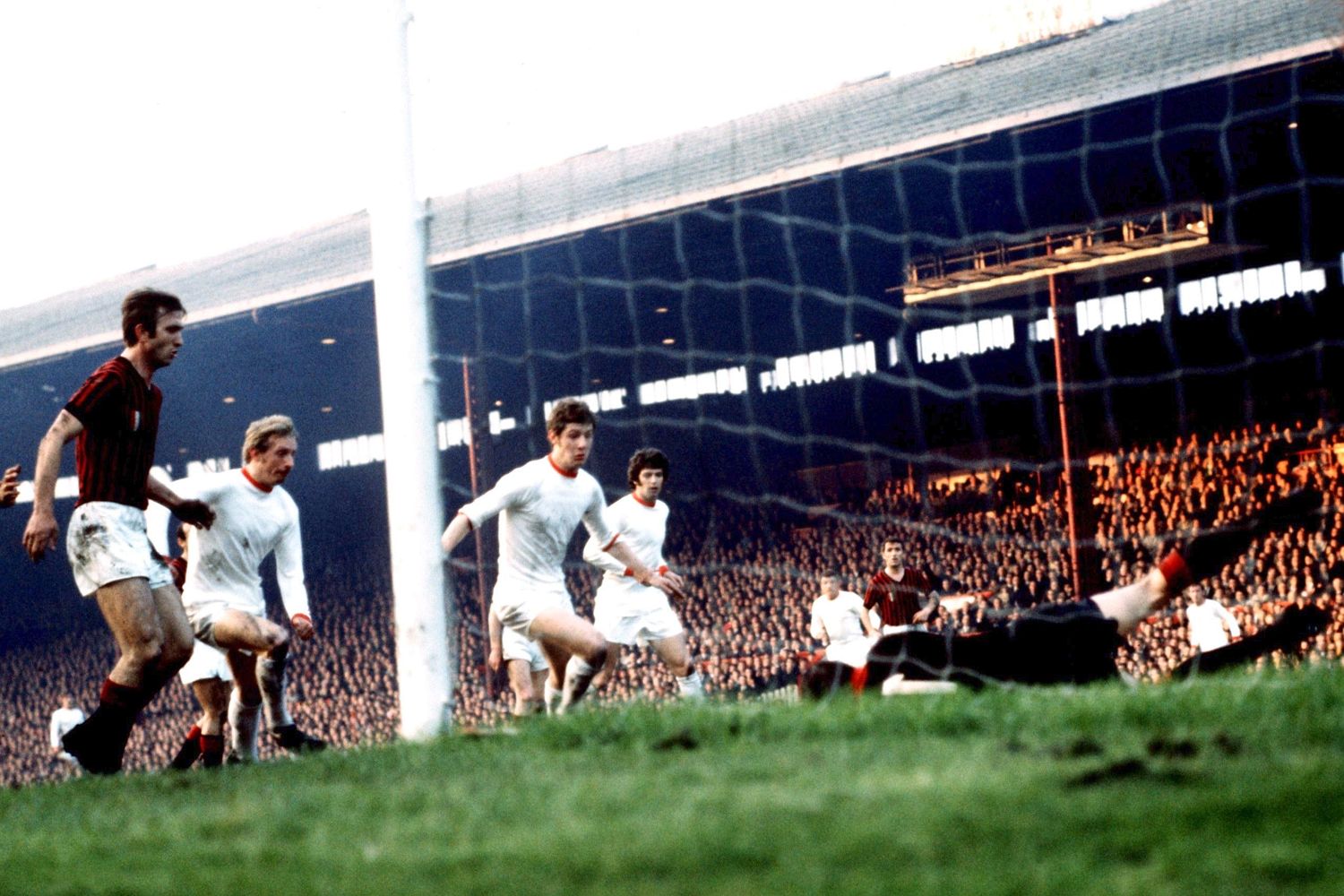 Denis Law scrambles the ball into the net