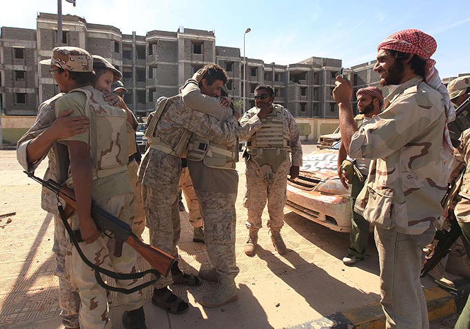 Anti-Gaddafi fighters hug as they celebrate the fall of Sirte October 20, 2011. Libyan interim government fighters captured Muammar Gaddafi's home town on Thursday, extinguishing the last significant resistance by forces loyal to the deposed leader and ending a two-month siege