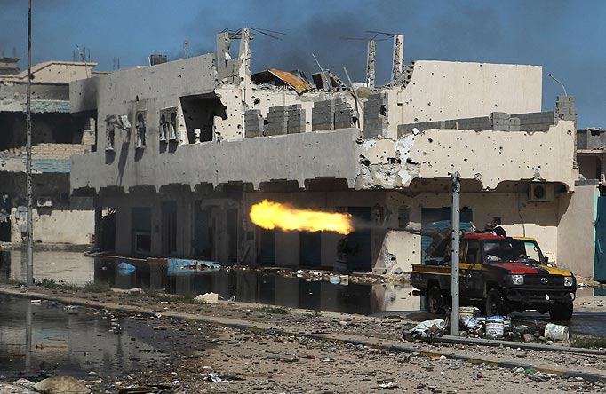 Anti-Gaddafi fighters fire heavy machine gun towards Gaddafi forces during clashes in Sirte, October 14