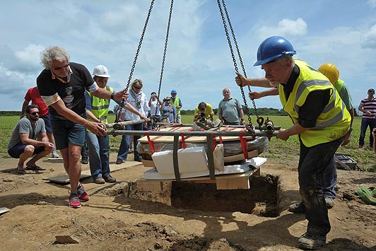 Metal detector Reg Mead (centre, back, blue polo shirt) watches as archaeologists unearth a Celtic coin hoard which he found with colleague Richard Miles. See SWNS story SWCOINS; Two metal detector enthusiasts have uncovered Europe's largest hoards of Iron Age coins worth up to £10 million - after searching for more than 30 YEARS. Determined Reg Mead and Richard Miles spent decades searching a field in Jersey after hearing rumours that a farmer had discovered silver coins while working on his land. They eventually struc