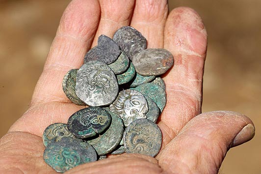 Archaeologists on Jersey unearth a Celtic coin hoard thought to be worth £10 million. See SWNS story SWCOINS; Two metal detector enthusiasts have uncovered Europe's largest hoards of Iron Age coins worth up to £10 million - after searching for more than 30 YEARS. Determined Reg Mead and Richard Miles spent decades searching a field in Jersey after hearing rumours that a farmer had discovered silver coins while working on his land. They eventually struck gold and uncovered between 30,000 and 50,000 coins, which date from the 1st Century BC and have lain buried for 2,000 years. The Roman and Celtic silver and gold coins were entombed under a hedge