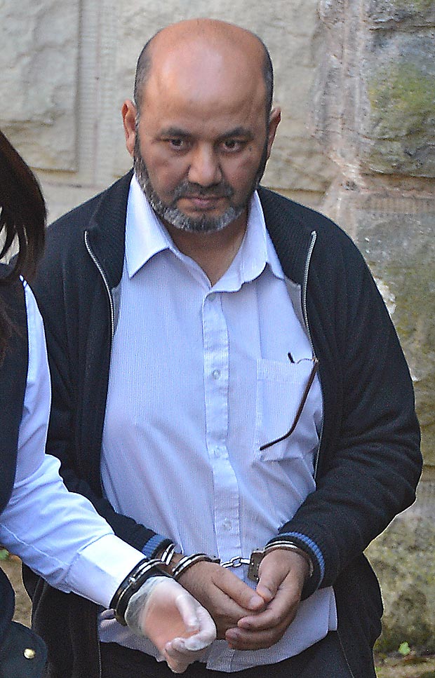 Pictured being led away in handcuffs to a prison van at Chester Crown Court is Iftikhar Ahmed.