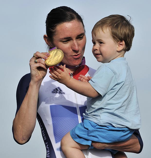 Britain's Sarah Storey and her nephew Gethin nspect her gold medal on the podium after she won the women's individual C4-5 road race cycling final