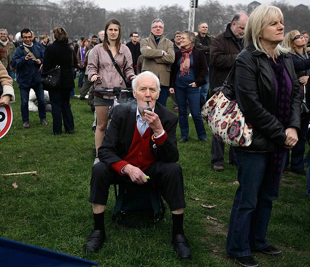 Former Labour politician Tony Benn (seated) smokes a pipe as he attends a rally in Hyde Park, during a protest organised by the Trades Union Congress (TUC), calle