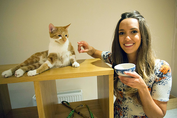 un reporter Jenny Francis visits the Cat Emporium cafe in Bethnal Green Road east London where customers can mingle with cats whilst having tea and cake. Picture shows Sun reporter Jenny Francis inside the cafe. Today Friday 4th April 2014. The Sun Picture by Peter Jordan