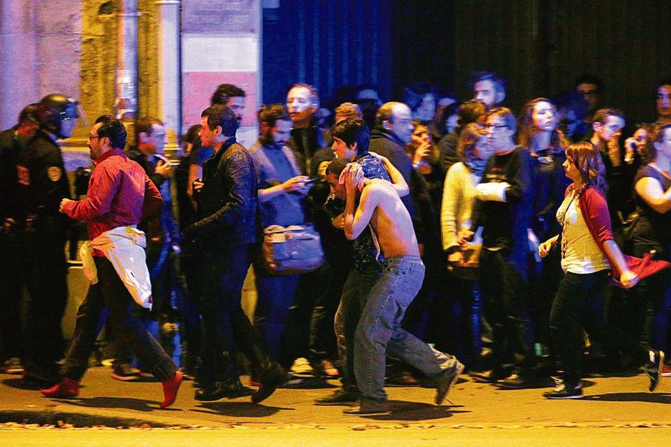  Injured music fans are led from the theatre after gun-toting suicide bombers attacked