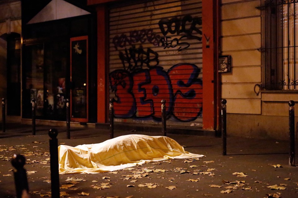  Bloodied victims were left coverd on the streets outside the Paris theatre during the attacks in November