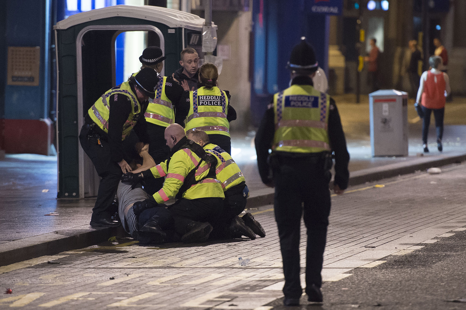 evellers out in Cardiff City centre, South Wales, on Black Friday. Black Friday, also known as Mad Friday, is traditionally one of the busiest nights of the year for pubs and clubs. Picture shows police restraining a man on St. Mary&