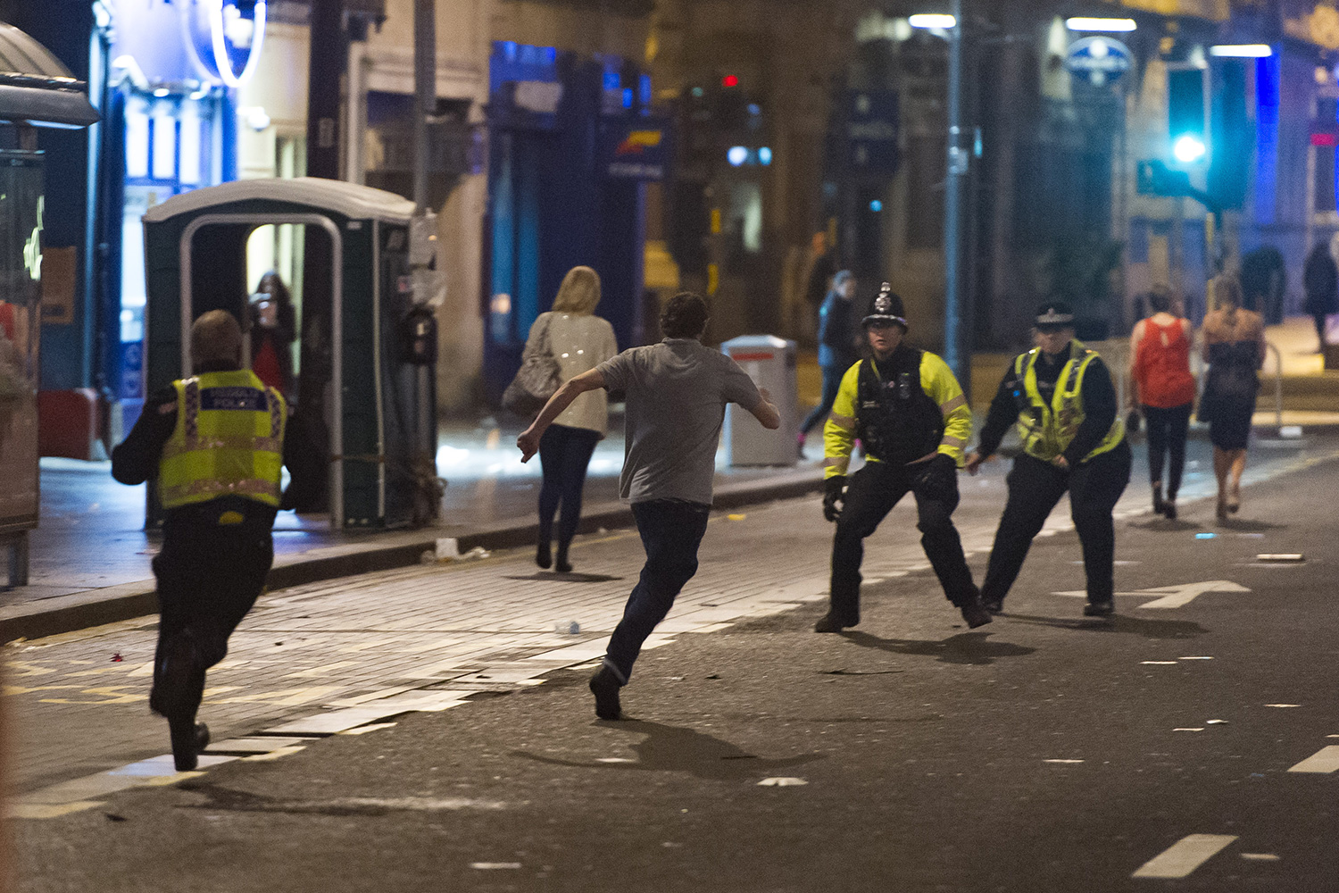 Pictured: A man runs away from police before being caught and put in handcuffs. Re: Mad Friday in Cardiff, south Wales, UK. Early hours of Saturday 19 December 2015