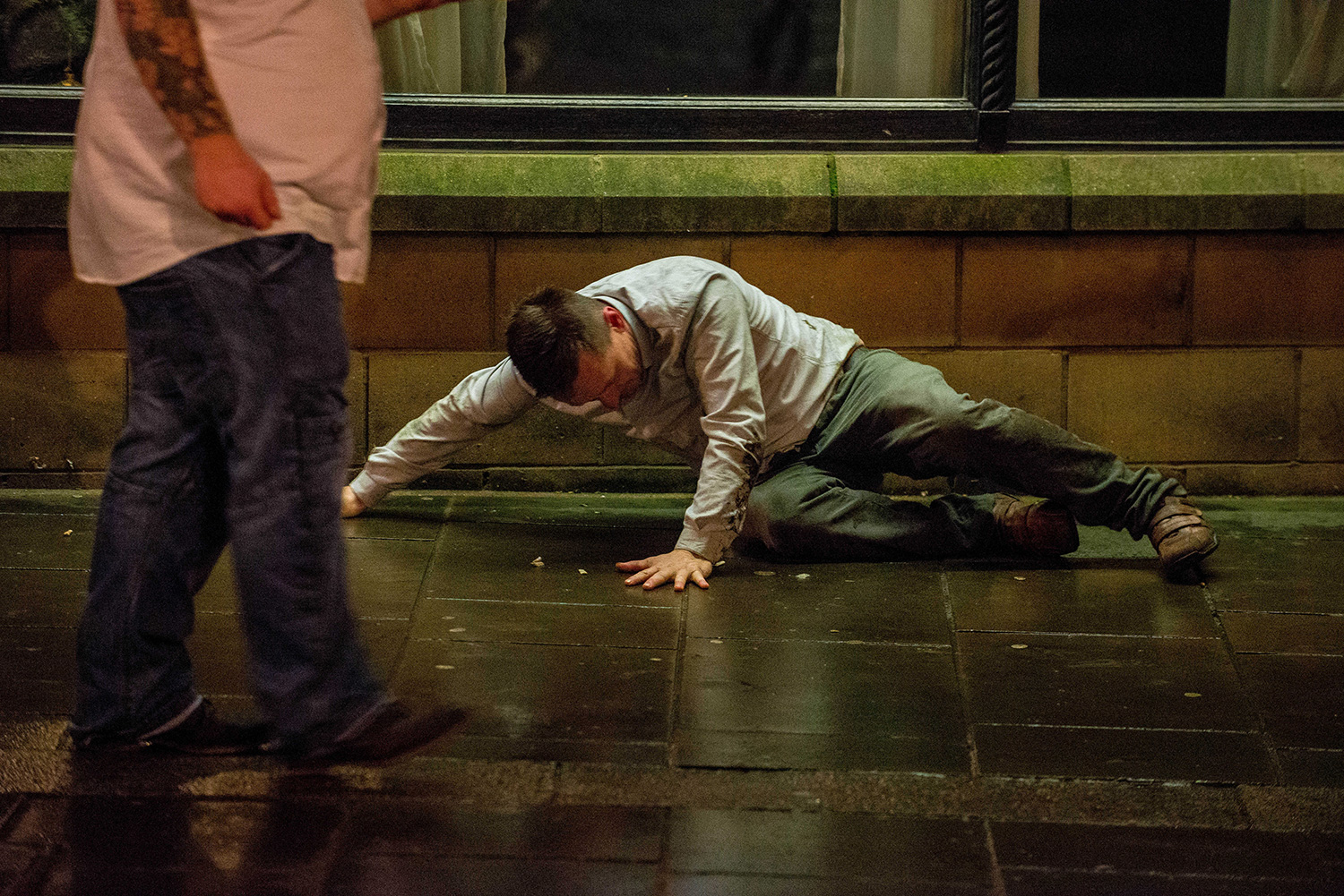 A man lies on the floor on Swansea's Wind Street Re: Mad Friday drinkers on the streets of Swansea South Wales on the busiest day of the year for the city's Bars and Clubs