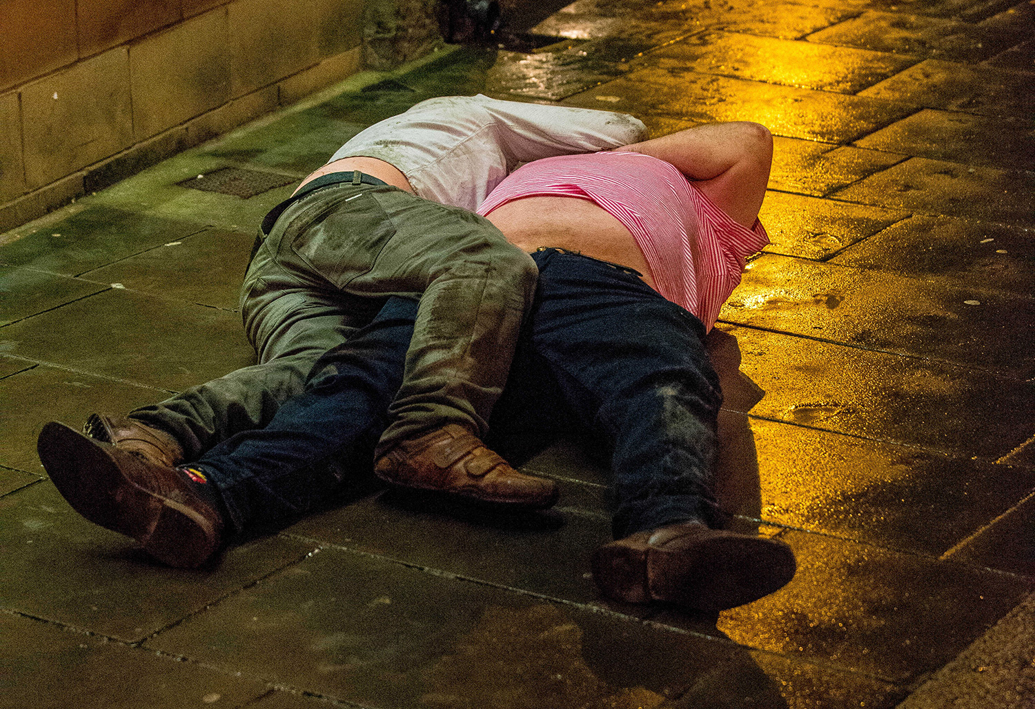 Pictured: Two men lie on the floor on Swansea's Wind Street Re: Mad Friday drinkers on the streets of Swansea South Wales on the busiest day of the year for the city's Bars and Clubs