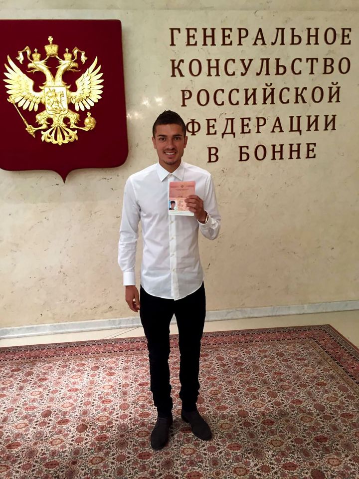  Roman Neustadter poses with his passport after switching to Russian nationality