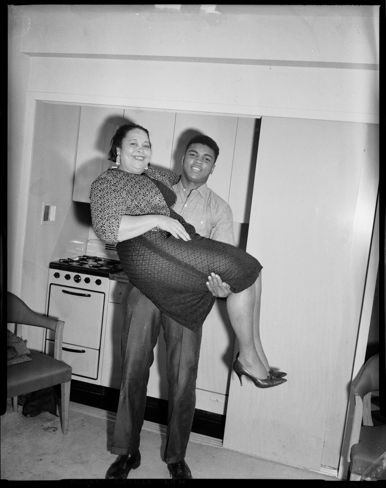  Boxer Muhammad Ali lifting his mother Odessa Grady Clay, in room at Carlton House Hotel, Pittsburgh, Pennsylvania, 1963