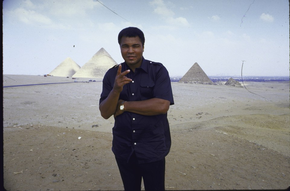  The ex-boxer Muhammad Ali veeing fingers in front of Pyramids of Giza