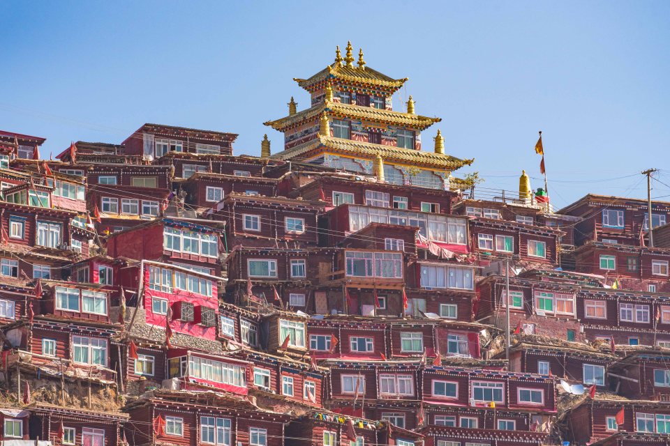  Among the tiny shacks are golden Buddhist temples, also perched precariously on the mountainside