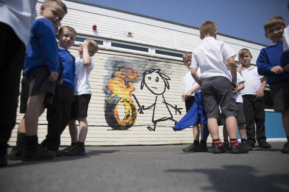  Children admire the Banksy mural at their primary school