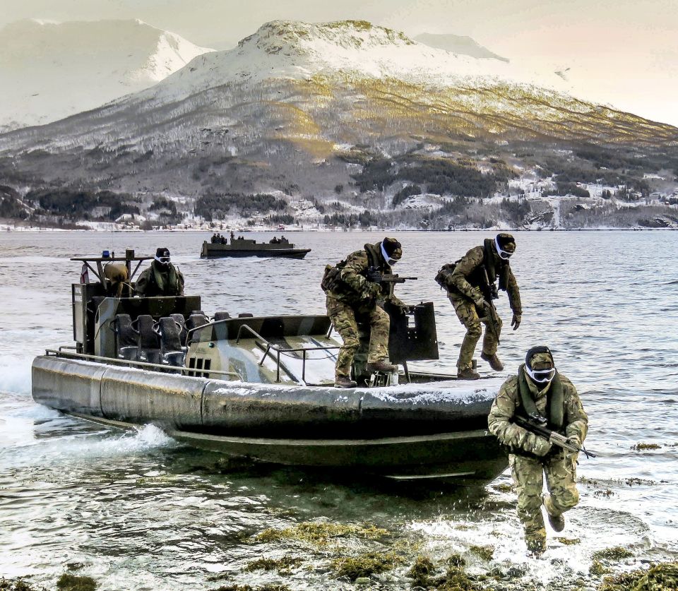  Royal Marines and Royal Navy personnel from 539 Assault Squadron carry out an beach assault, with an offshore raiding craft in Norway