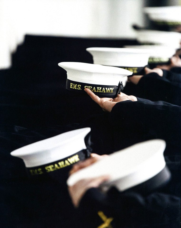  This simple image evokes an emotive response as sailors stand in a line holding out their hats embossed with the name of their ship - HMS Seahawk