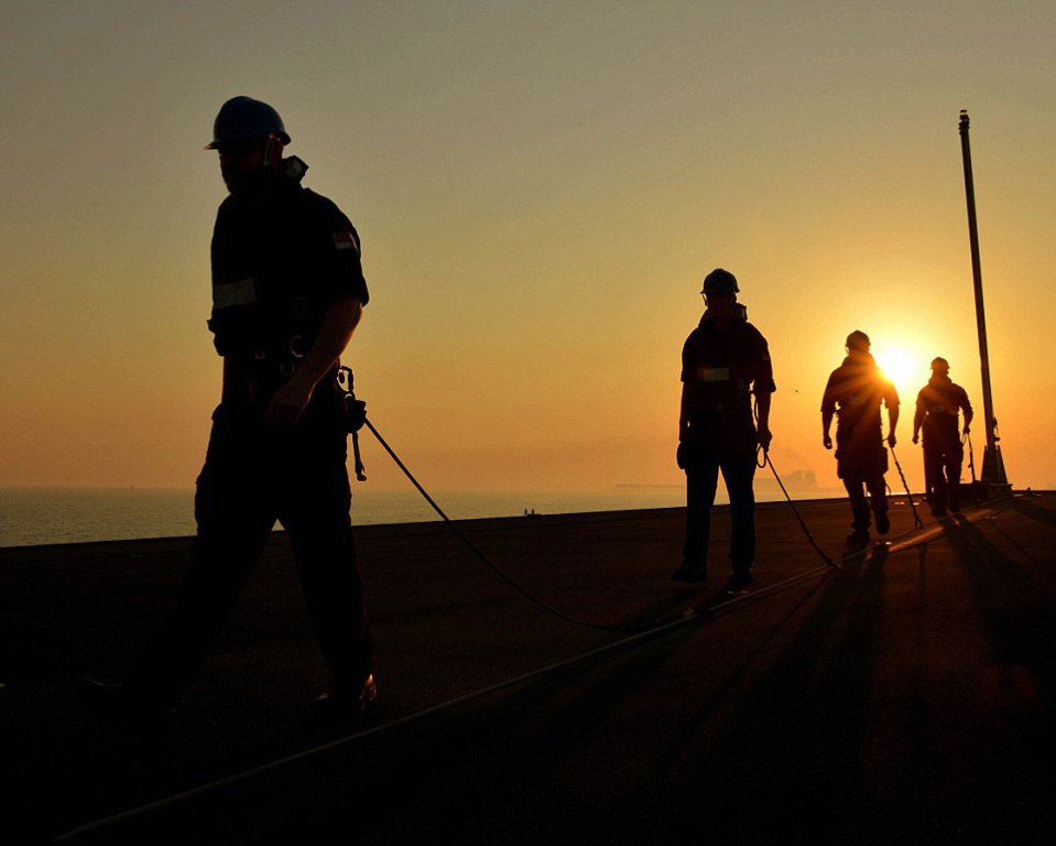  Royal Navy sailors are captured as the sun sets in Bahrain, after they have erected the Jack Staff on board HMS Defender during Operation Kipion