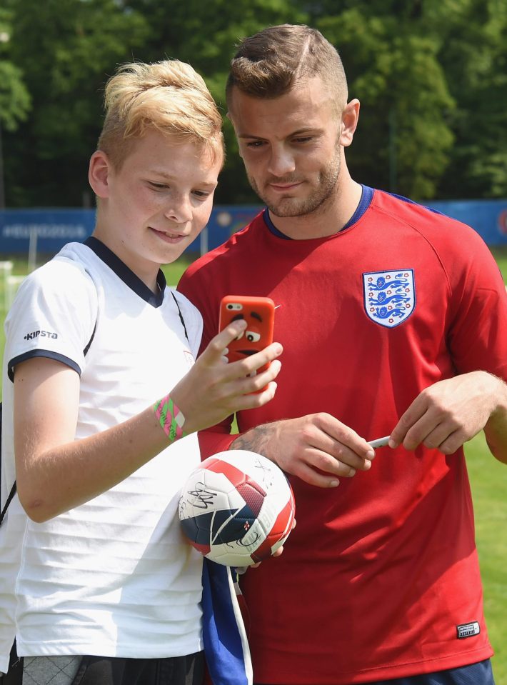  Jack Wilshere poses for a selfie with a fan after the open training session