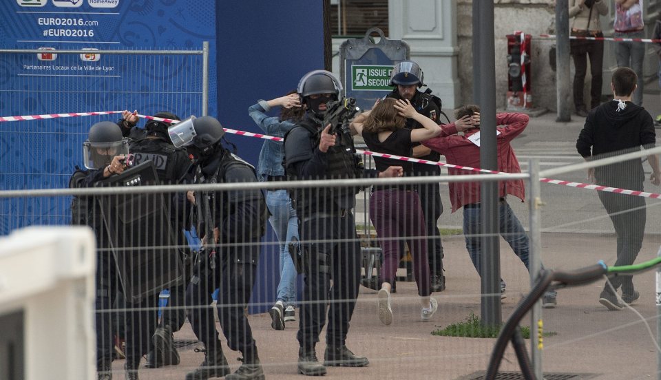  Fans run to safety as armed cops search for the masked gunmen