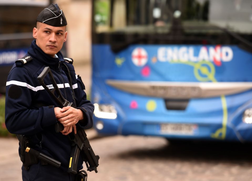 An armed police officer stands by the te