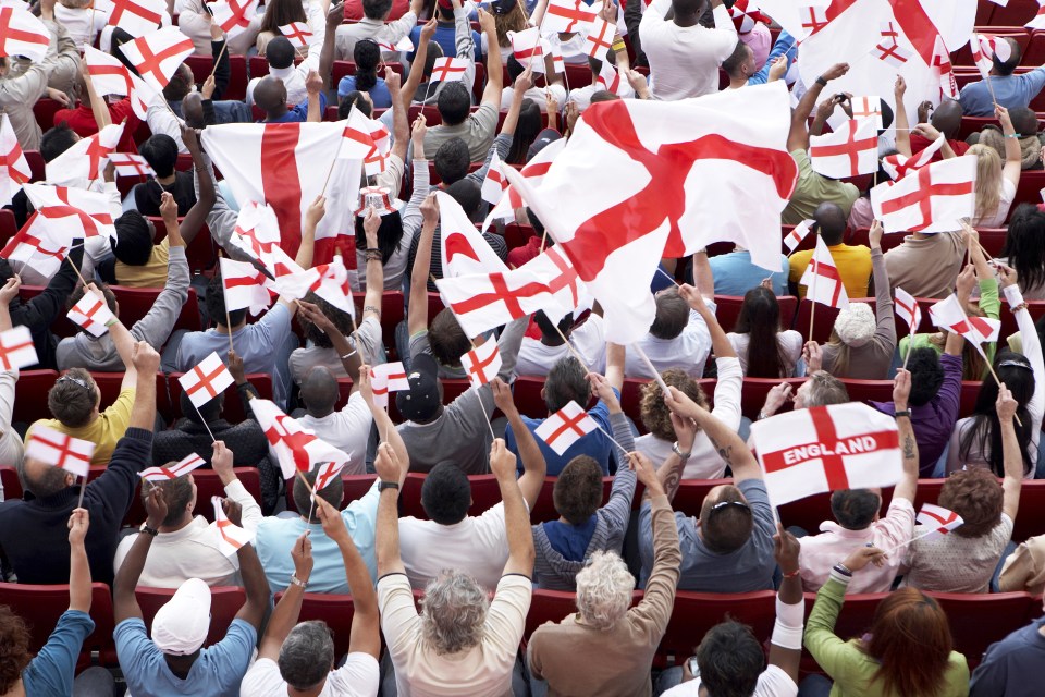 Crowd of fans cheering with St. George's flags