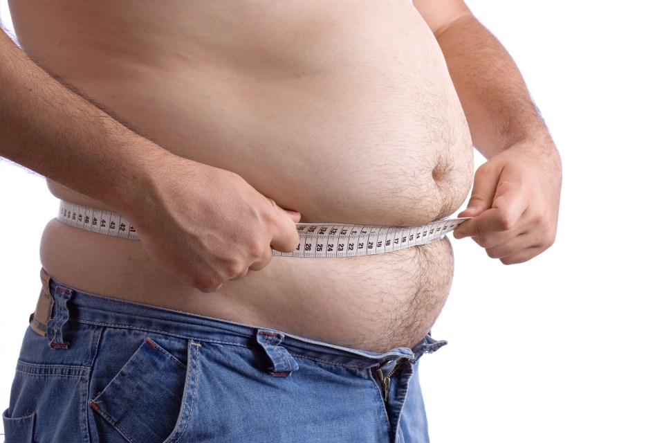 Fat man holding a measurement tape against white background. Image shot 2006. Exact date unknown.