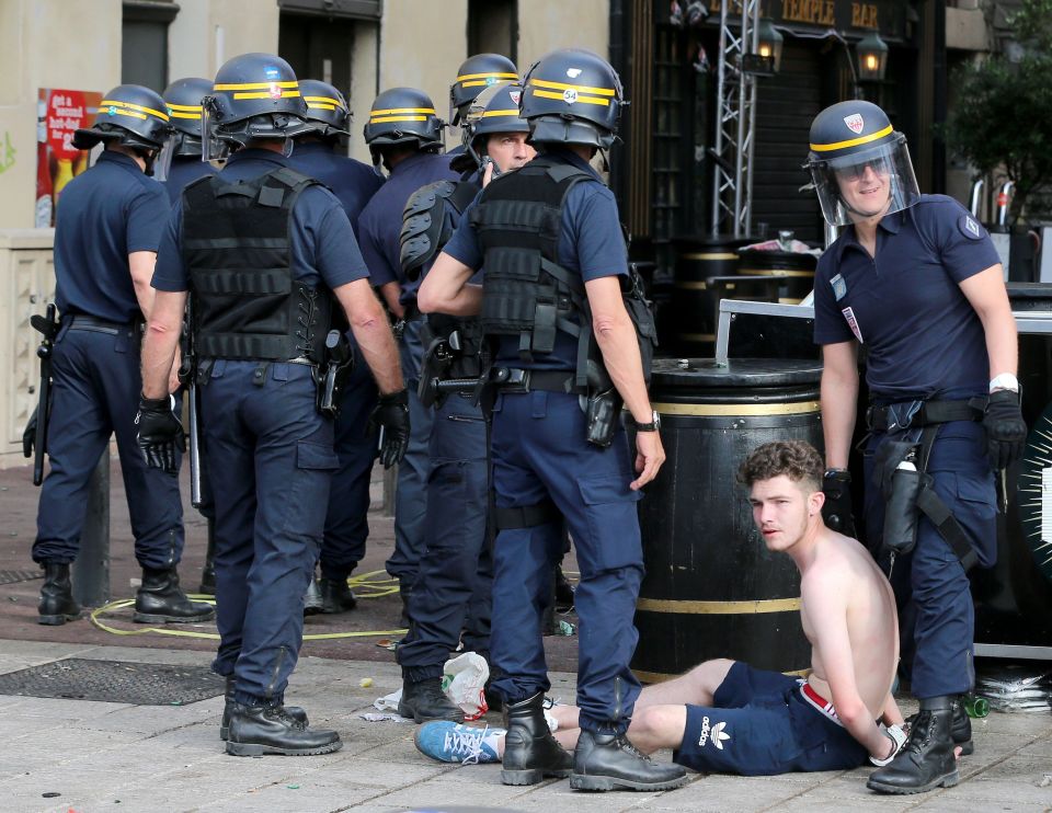  Police restrain a man following clashes with English fans...