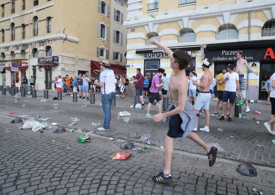  England fans who have been drinking for most of the day throw empty cans...