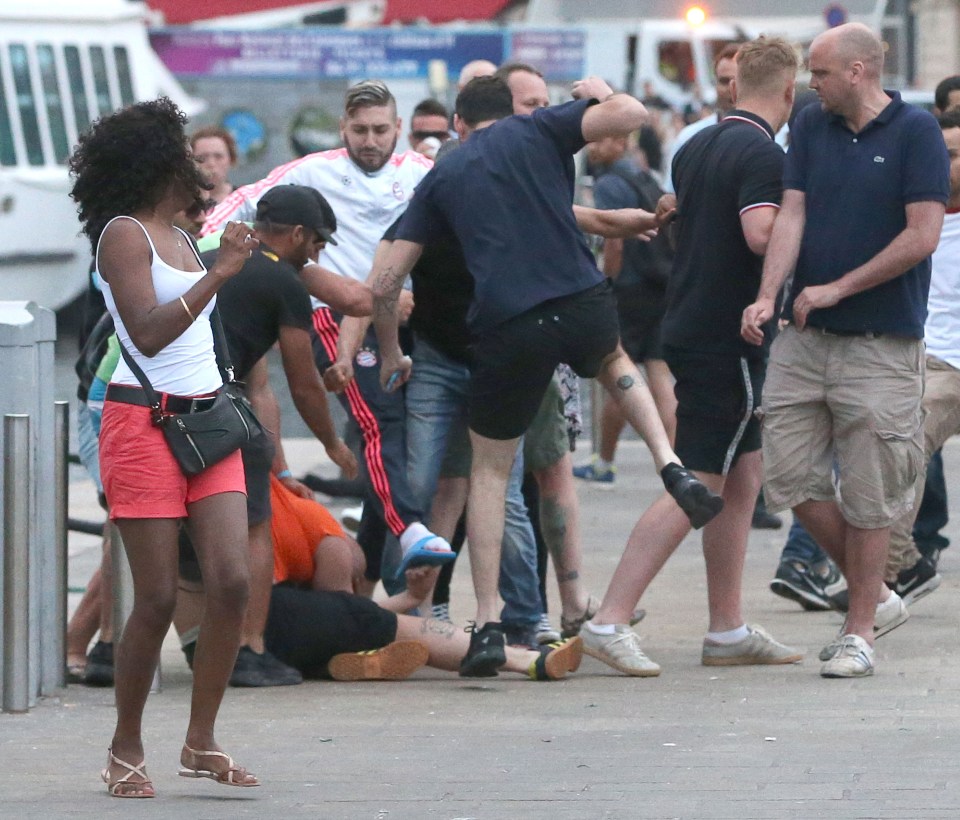  A fan believed to be English is kicked to the floor in street brawls...