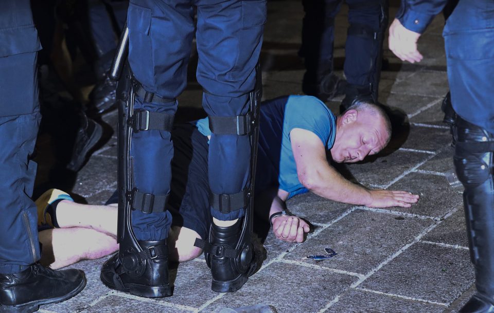  Another supporter lies injured on the floor as French police come to his aid