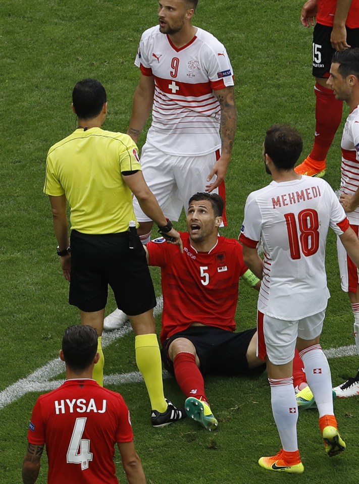  Albania captain Lorik Cana knows a red card is coming after his handball