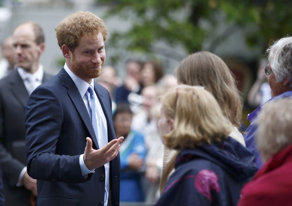 Britain's Prince Harry greets guests on the Mall as they attend the Patron's Lunch, an event to mark Queen Elizabeth's 90th birthday, in London