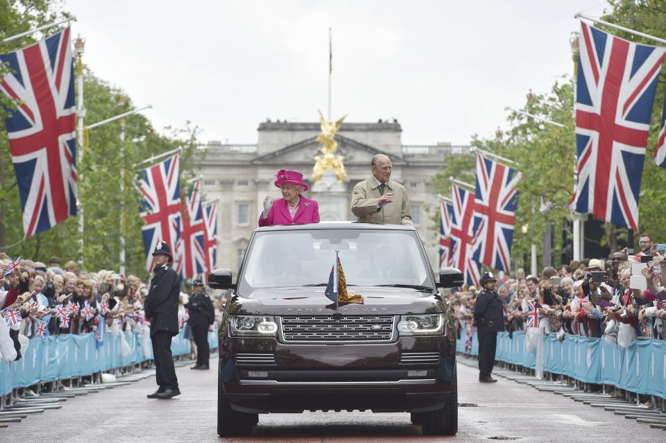 Queen Elizabeth II and Britain's Prince Philip, Duke of Edinburgh wave to guests as they visit the Patron's Lunch, a special street party outside Buckingham Palace