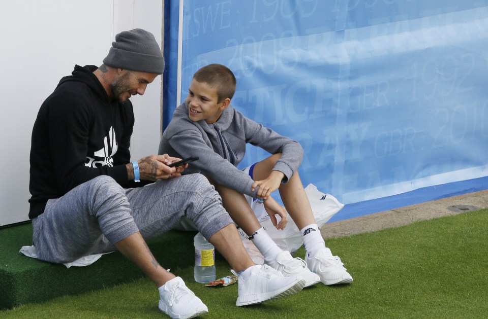  David and Romeo Beckham hang out as dad David plays with his smartphone