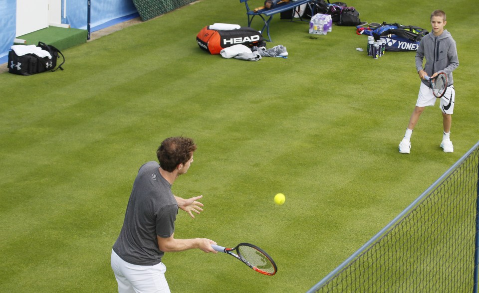  Andy Murray hits a forehand back towards Romeo Beckham as they have a hitting session ahead of the Aegon Championships at Queen's Club in London