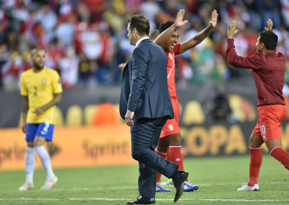  Dunga walks past the Peruvian players who celebrate a sensational victory