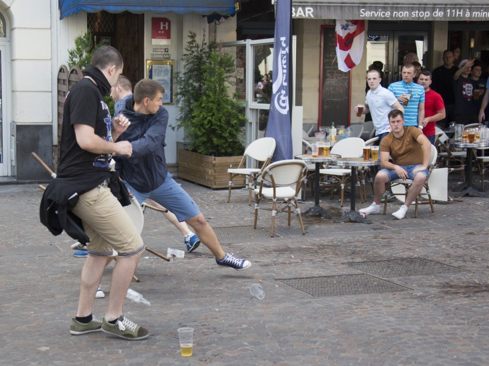  A Russian yob throws a chair as trouble erupted in Lille last night. Minutes later the fan in brown is knocked out cold