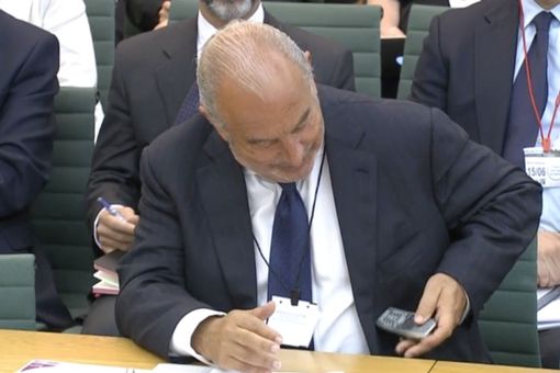  Sir Philip Green checks his very old phone during the Commons select committee hearing