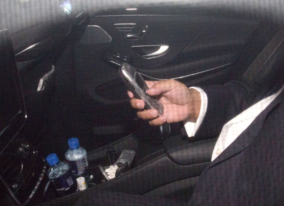  Is he playing Snake 2? Sir Philip Green's taps his old Nokia phone before getting out of his vehicle