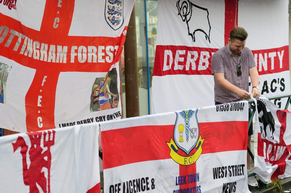  A supporter attaches a modified England flag next to others in Lens